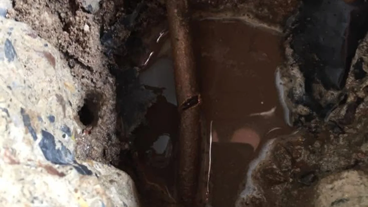 Burst pipe repair Adelaide — corroded water pipe excavated showing split and water pooling underground