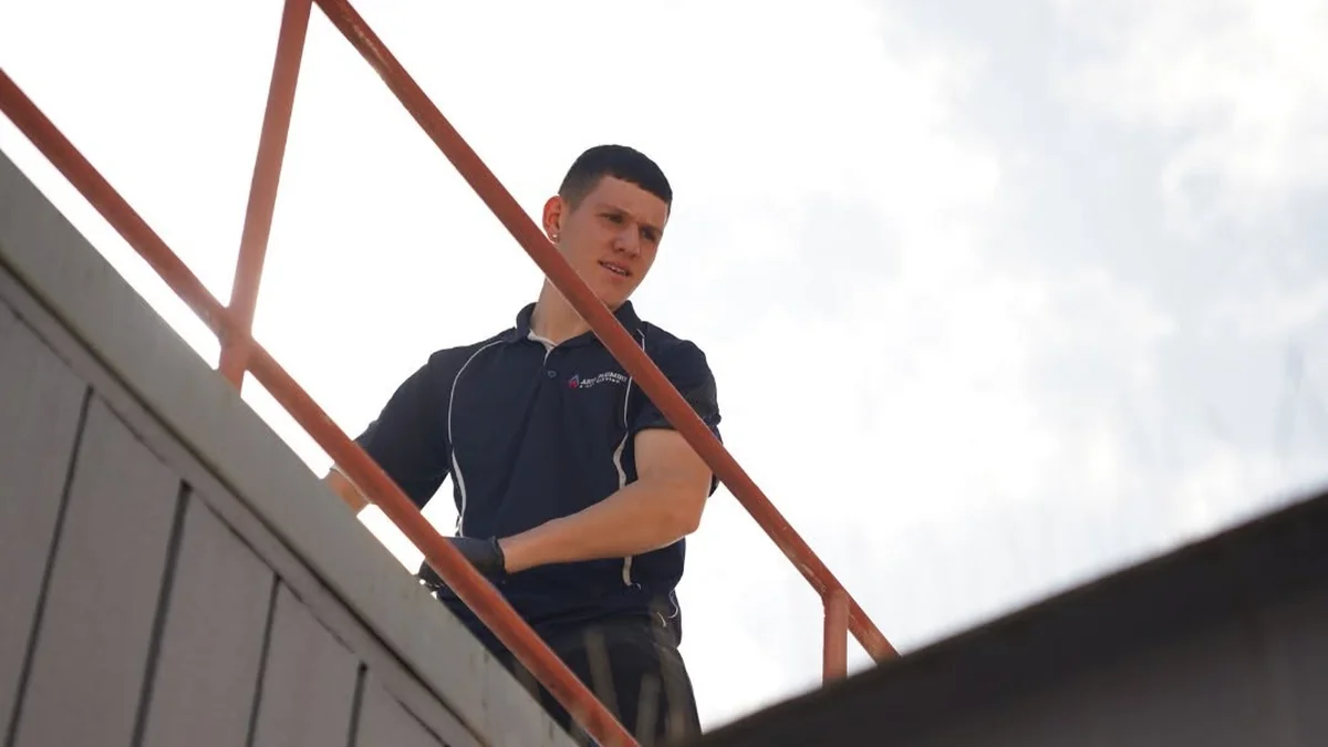 Commercial roof plumber Adelaide — licensed plumber on commercial building roof inspecting roof plumbing
