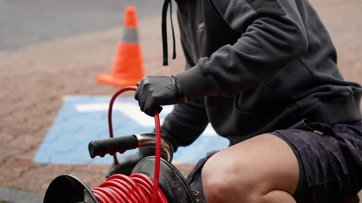 Adelaide Emergency Plumbing technician using high-pressure water jetting to clear a blocked drain on-site